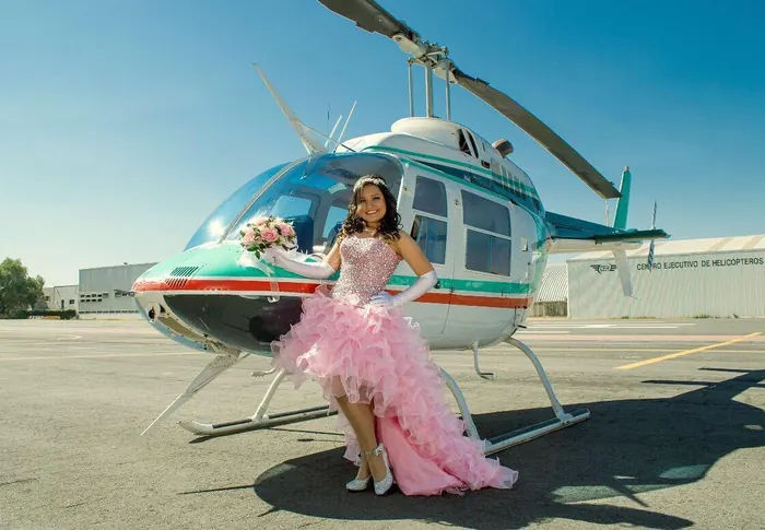 Quinceañera junto a un helicóptero